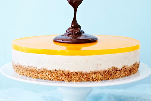 Layered clementine cheesecake, with chocolate sauce poured over