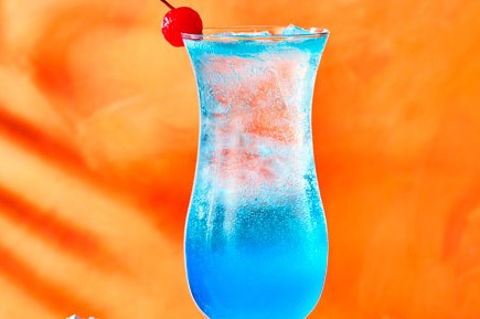 Blue lagoon cocktail in glass with cherry garnish