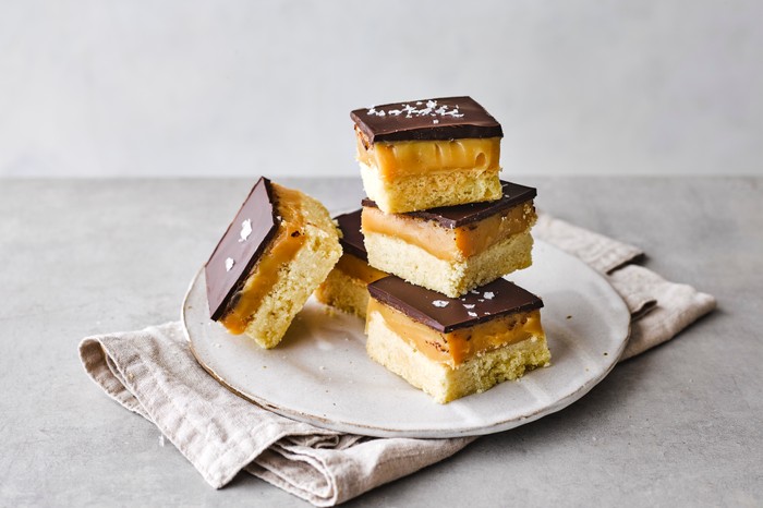 A pile of millionaire's shortbread squares on a plate