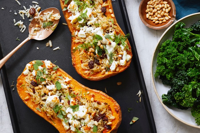 Two butternut squash halves stuffed with feta, rice and sultanas