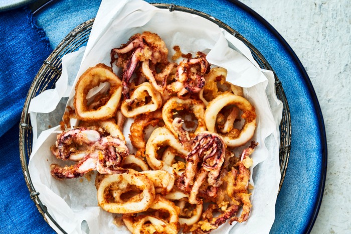 A blue plate topped with golden crispy rings of squid