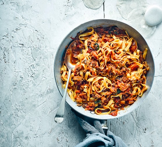 A large silver pot full of vegan bolognese with mushrooms