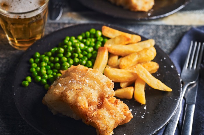 Beer battered cod, chips and peas on a plate dinner plate