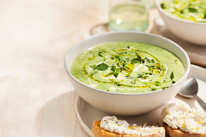 Pea and Mint Soup in a Bowl with Small Ricotta Toasts