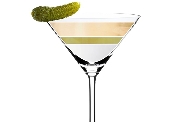 A martini glass filled with vermouth and gin and topped with a pickle