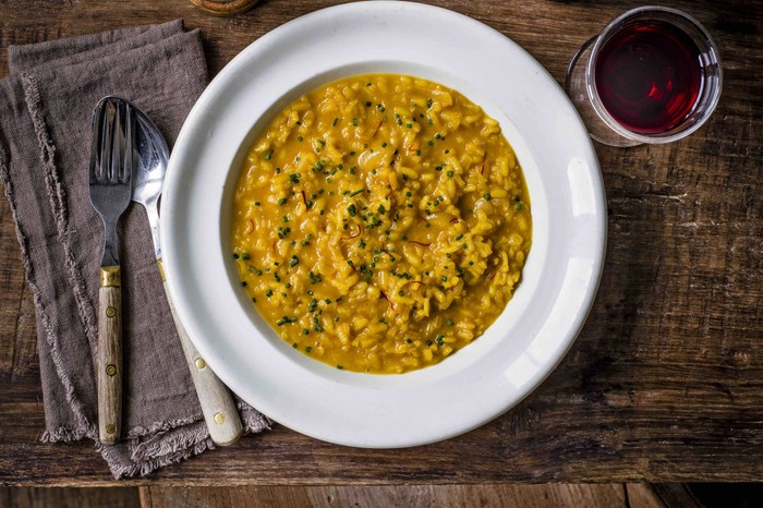 An aerial shot of saffron-coloured risotto on a white plate