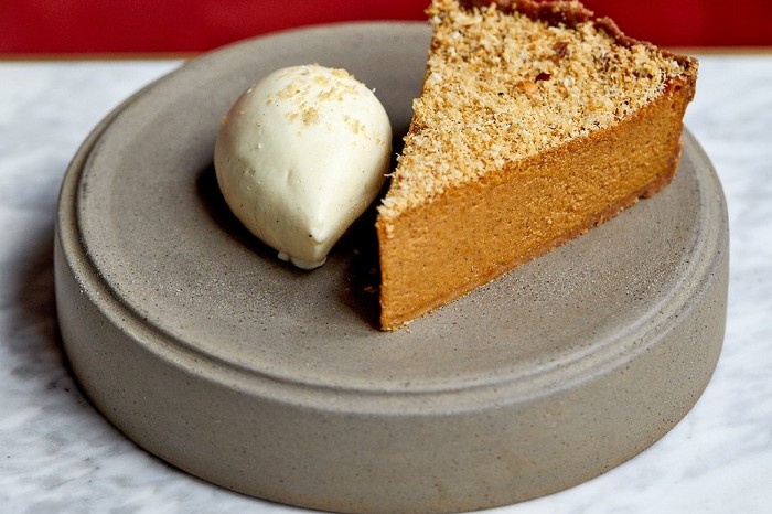 Spiced pumpkin tart on a grey plate with a red background